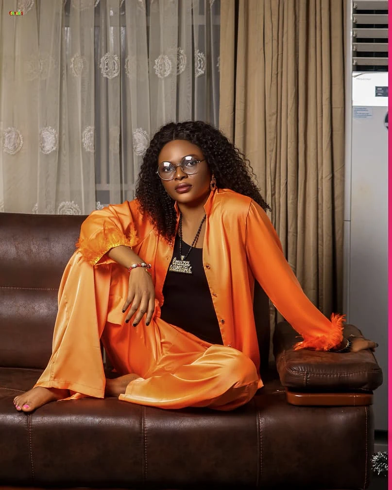 Louiza Williams seated in orange outfit